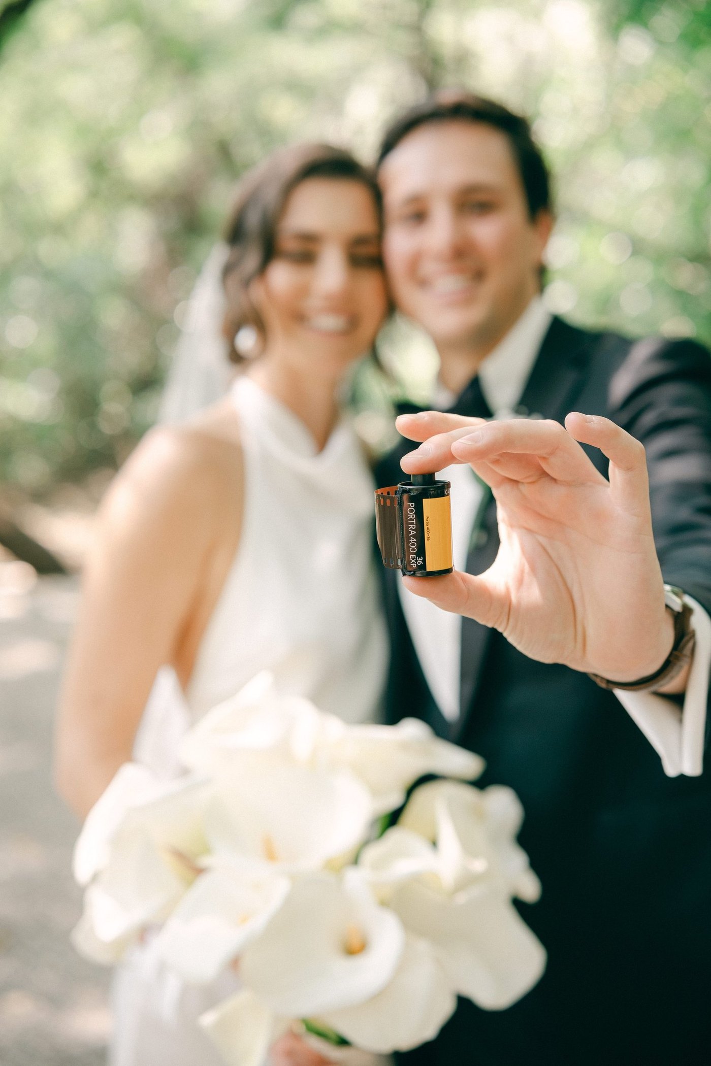 Smiling couple holding up a roll of film toward the camera