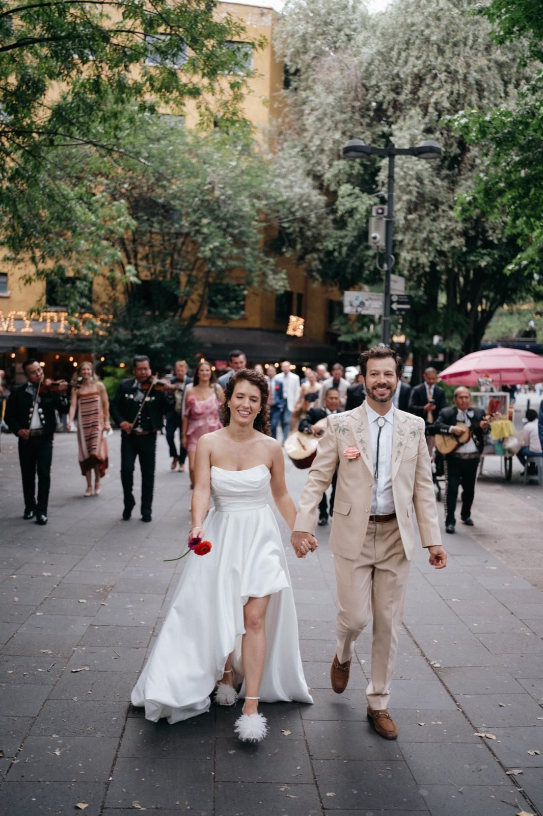 Fabiana and Colin walking with mariachis in Mexico City