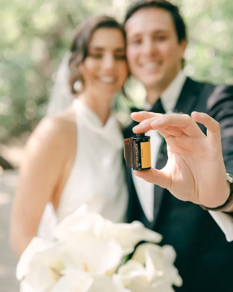 Kiara and Pablo holding a roll of film on their wedding day
